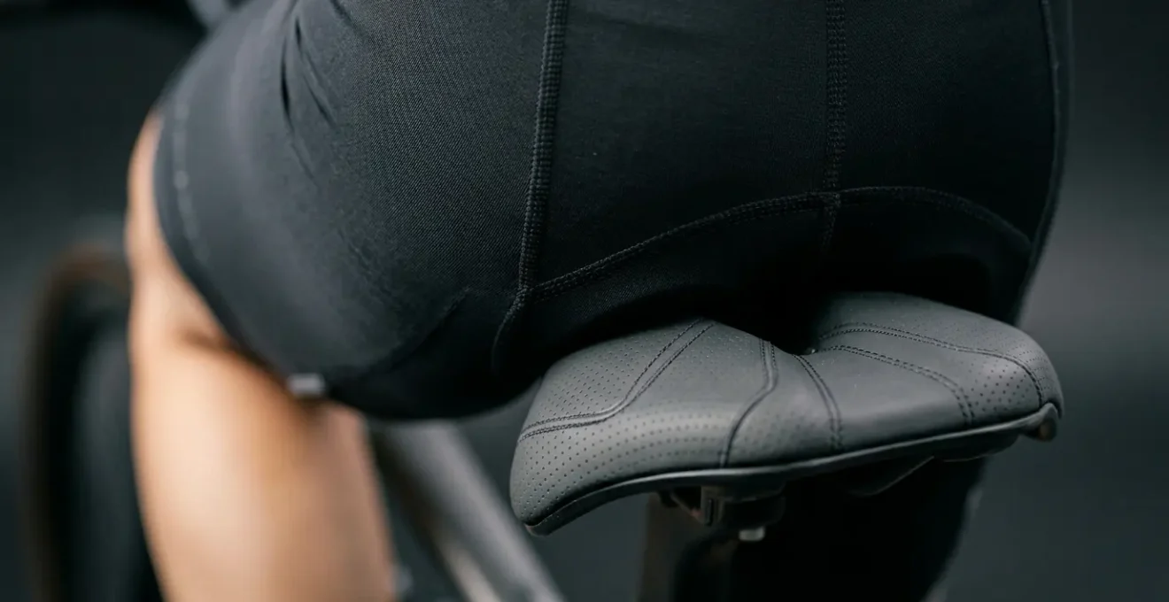 Gros plan photographique sur la zone de contact entre le bassin et une selle de vélo, montrant la géométrie et la largeur adaptée pour un confort optimal
