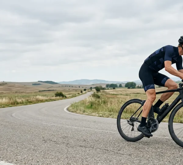 Cycliste professionnel en action sur route avec focus sur la biomécanique du mouvement de pédalage