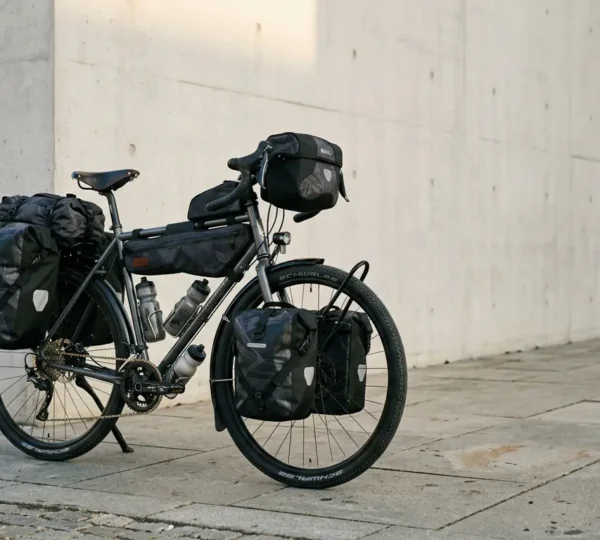 Cycliste urbain avec vélo équipé de sacoches remplies pour le quotidien