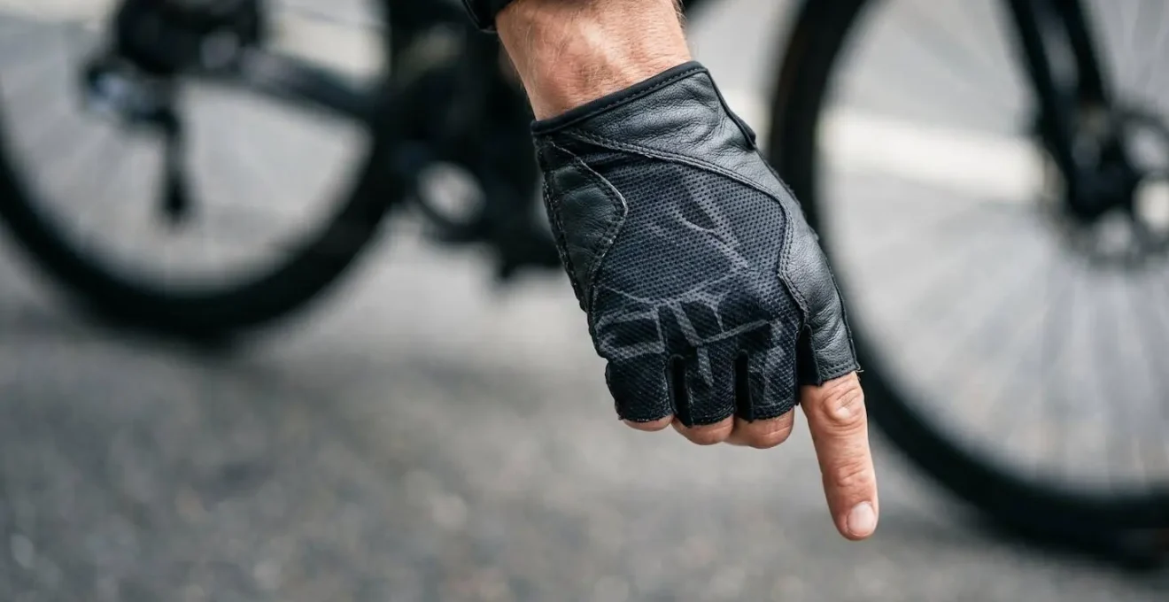 Mains de cycliste effectuant un signe de communication dans le dos