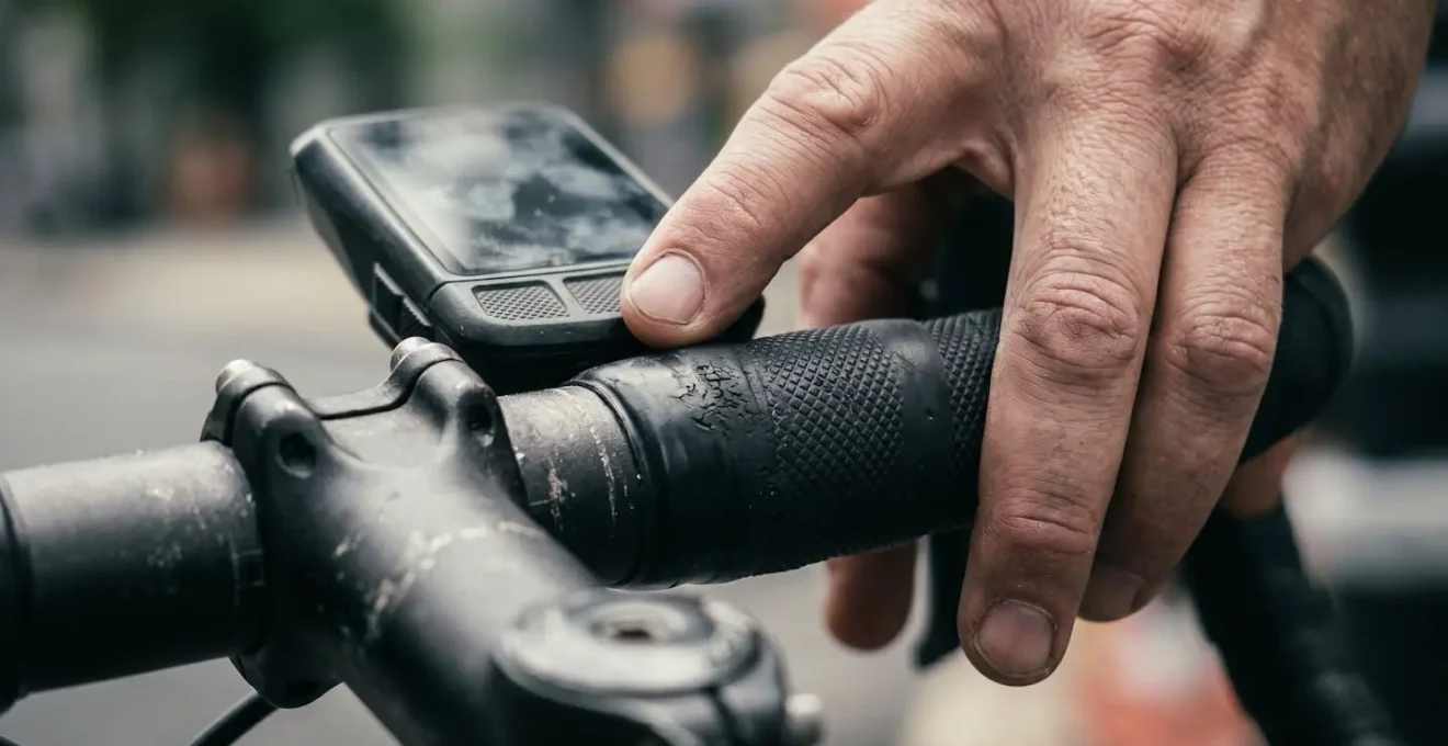 Gros plan sur les mains d'un cycliste ajustant sa cadence de pédalage sur un compteur de vélo