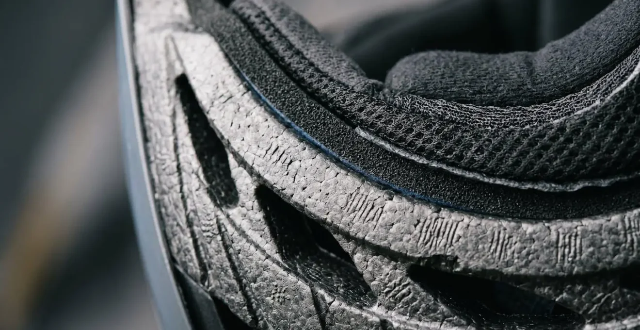 Vue macro de la structure interne d'un casque de vélo montrant les couches de protection et mousses absorbantes